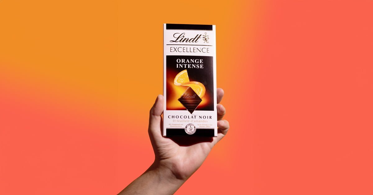 Food-Marketing mit SOCIALFOOD – kreative Inszenierung von Lindt Excellence Orange Intense Schokolade auf modernem, farbigen Hintergrund. Perfekte Food-Concept-Darstellung durch deine Foodwerbeagentur.