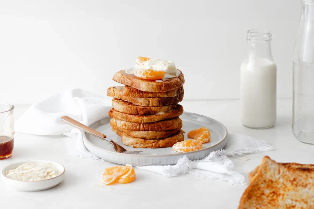 Food-Fotografie von French Toast mit Mandarinen und Sahne, inszeniert mit natürlichem Licht und minimalistischem Styling