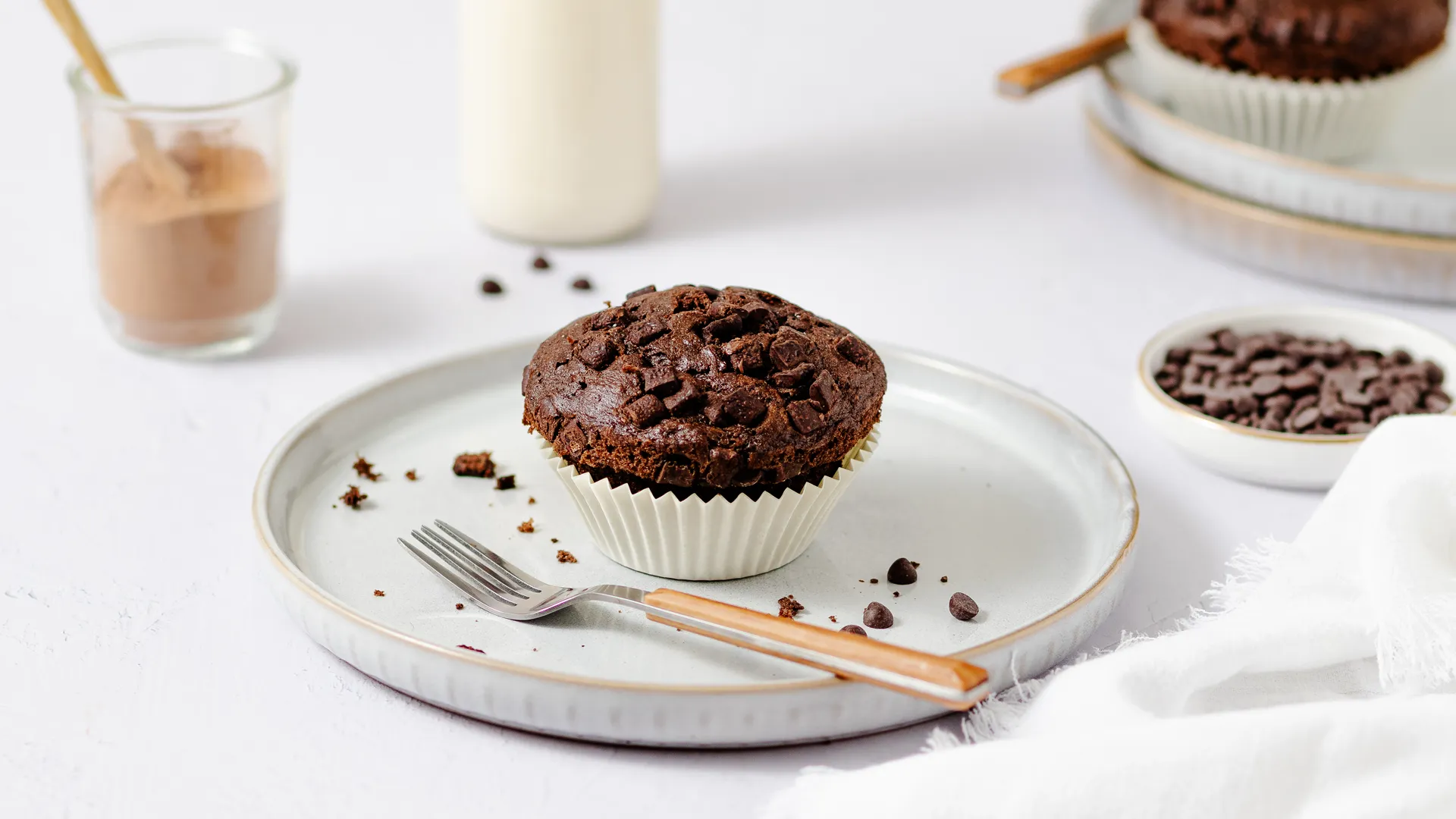 Minimalistische Food-Fotografie Trends 2025: Ein Schokoladenmuffin auf schlichtem Teller mit dezenten Requisiten, stilvoll inszeniert von Socialfood für puristische Eleganz.